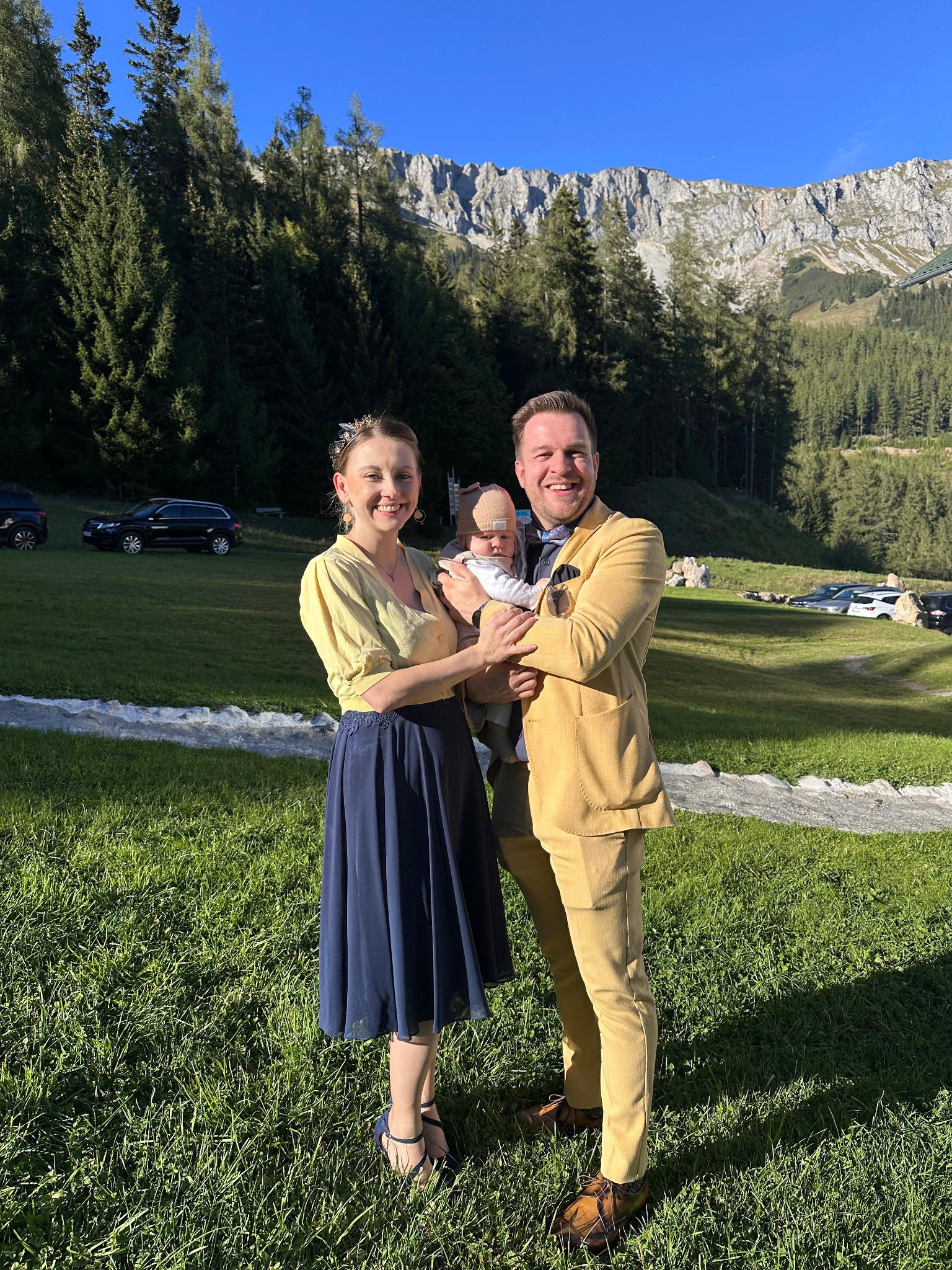 Magdalena und Daniel mit ihrem Kind vor einer Berglandschaft